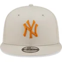 beige-flache-snapback-kappe-mit-orangefarbenem-logo-9fifty-league-essential-der-new-york-yankees-mlb-von-new-era