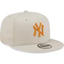 beige-flache-snapback-kappe-mit-orangefarbenem-logo-9fifty-league-essential-der-new-york-yankees-mlb-von-new-era